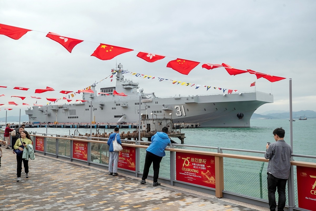 海南艦首次訪港，停泊後懸掛「滿旗」。圖為香港市民到岸邊一睹海南艦風采。（圖片來源：視覺中國）