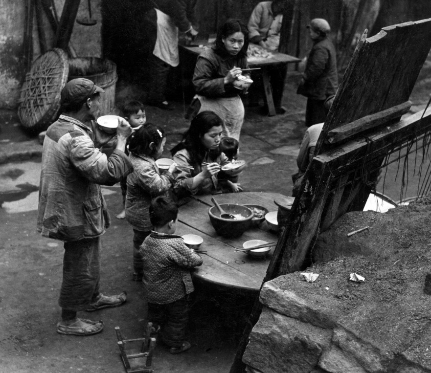 1950年代，一個家庭在街上吃飯。