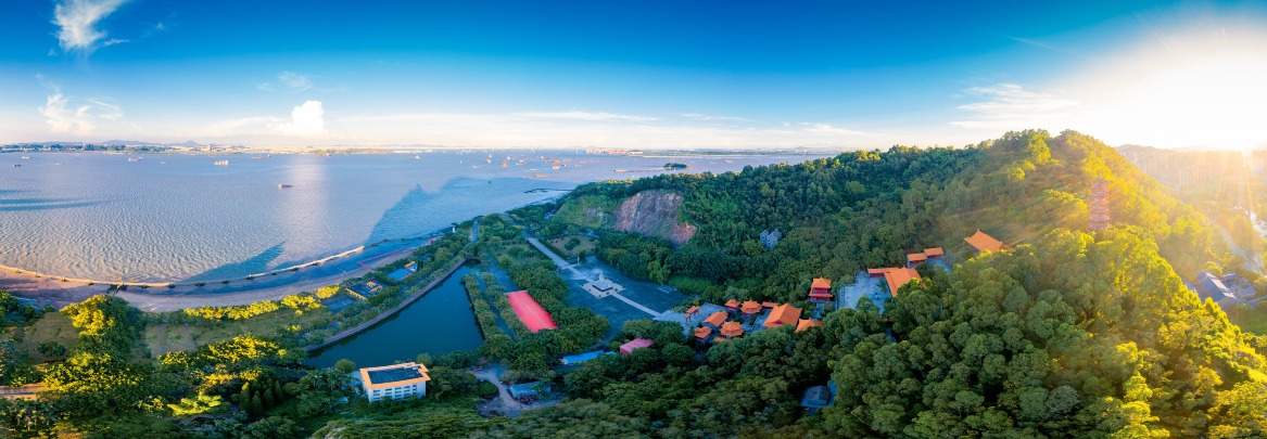 南沙天后宫位于南沙大角山东南麓，远看像一座宫殿。门前先有一座典雅的牌坊，四根立柱四句对联，横梁刻上“南沙天后宫”，旁边还有龙形浮雕，极具气势，殿前一座约5层楼高的天后像温柔地震慑四方。