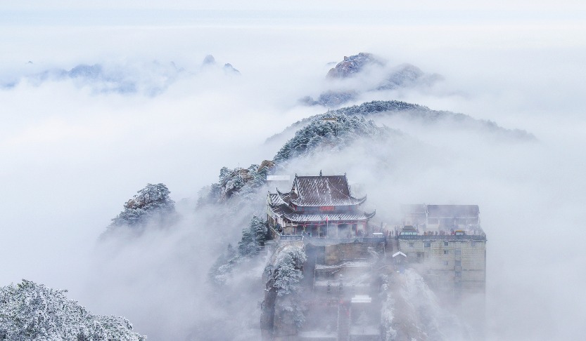 雪後的九華山，峰巒銀裝素裹，山頂上的道觀被層層冬覆蓋，白雪皚皚，美如仙境。