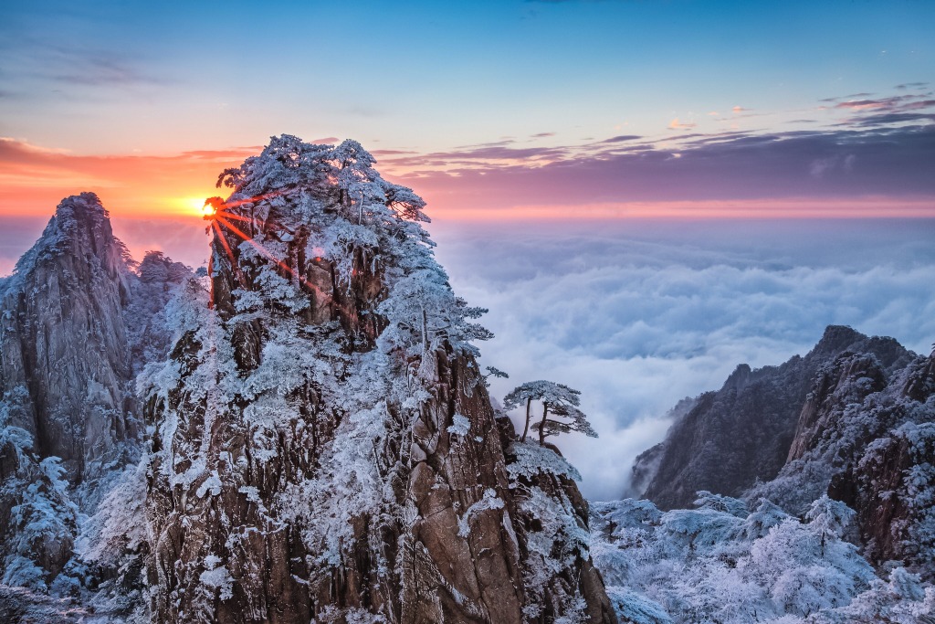 在寒冷的冬日，松樹上的水霧凍結成晶瑩剔透的霧凇，整座黃山變成潔白的冰雪世界，搭配飄渺雲海，美如仙境。