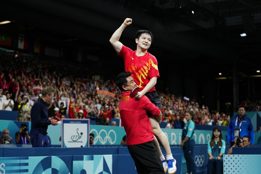 Fan Zhendong and his coach Wang Hao celebrate their victory